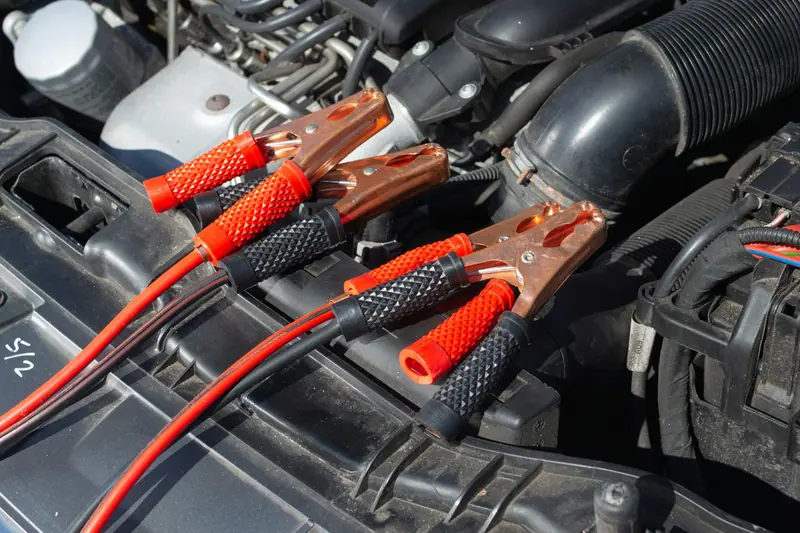 Starthilfekabel an den Batteriepolen im Motorraum