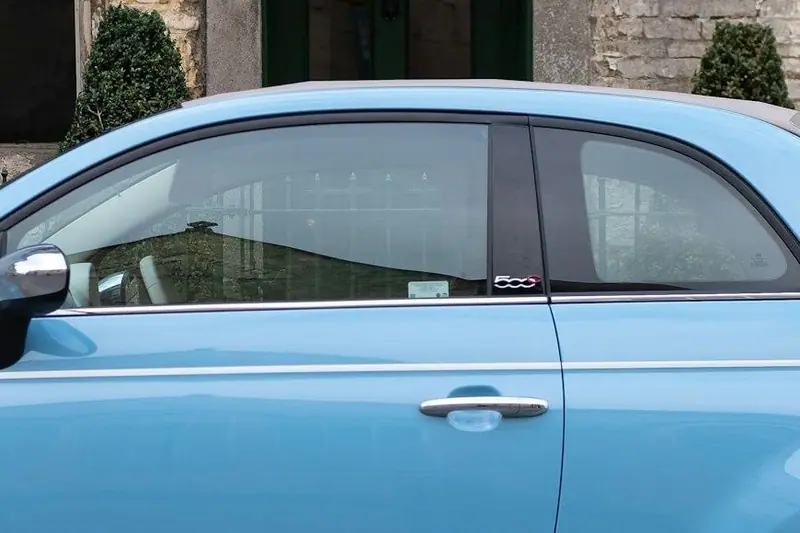 Tür und Seitenfenster des hellblauen Fiat 500
