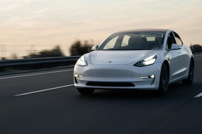 Tesla Model 3 in Fahrt auf der Autobahn bei Abendlicht