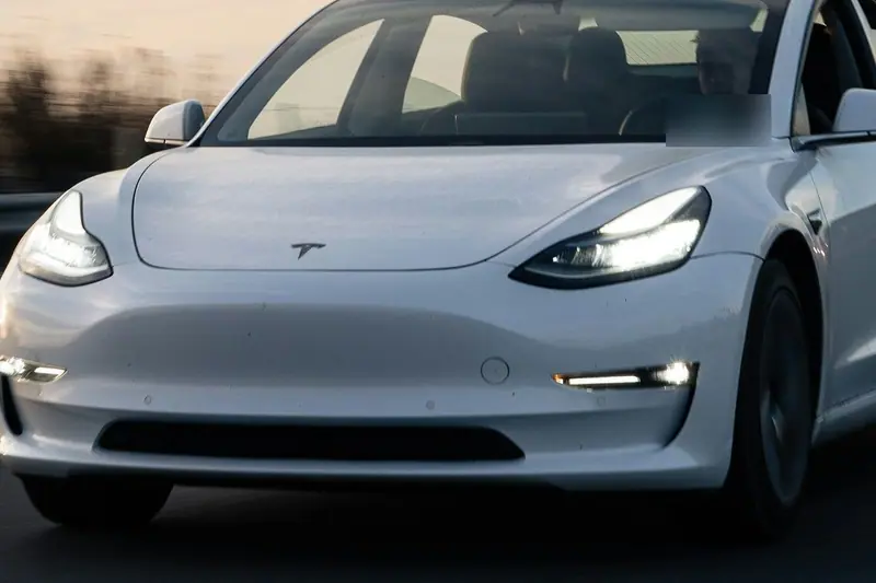 Tesla Model 3 von vorne mit eingeschaltetem Licht